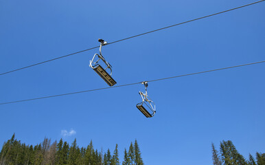 two chair lifts on blue sky background