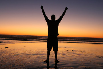 Fototapeta premium Man Raising Hands in Sunset
