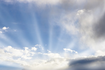Fototapeta na wymiar Sun rays emanating from sunlit clouds