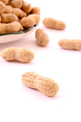 Few peanuts and dish isolated on white