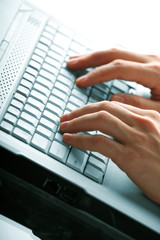 male hands typing on a laptop