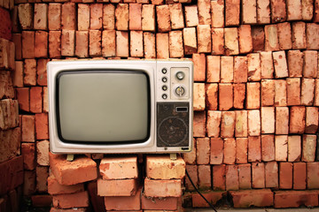 Old television nearby brick wall