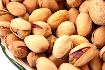 peanuts with shells on the plate isolated on white