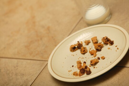Plate of cookie crumbs and empty glass