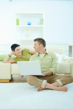 Couple using computer at home