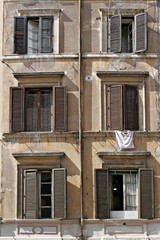six windows with laundry and shutters in rome