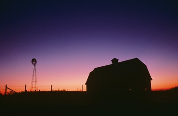 Silhouette of barn and windmill