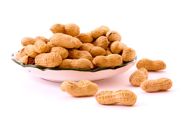 Few peanuts and dish isolated on white