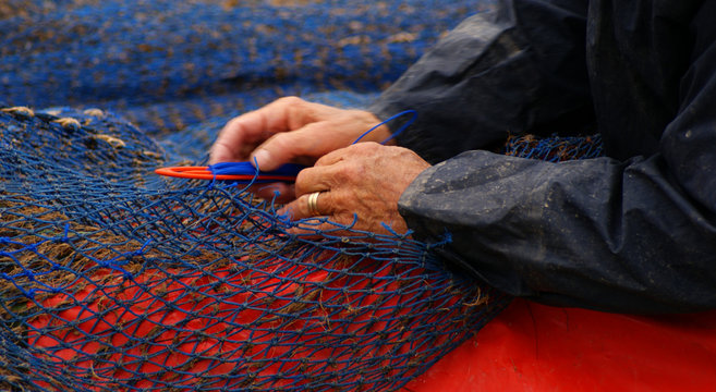 PESCADOR REPARANDO LAS REDES
