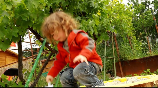 Jeune enfant jouant dans un bac &agrave; sable