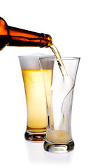Beer being pour on a glass over a white background