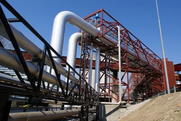 Photo sur Plexiglas Bâtiment industriel industrial pipelines on pipe-bridge against blue sky