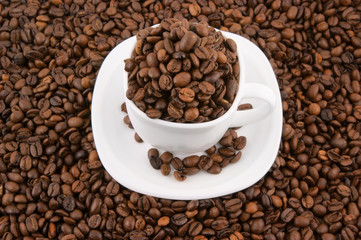 Cup of coffee filled up with coffee beans