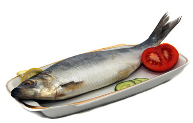 herring with tomato, cucumber and lemon on the dish