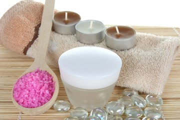 Obraz na płótnie Canvas cream and bath salt with towels and candles - body care