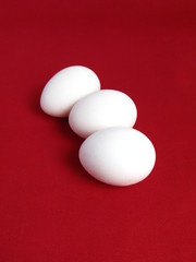 Group of three eggs on red background