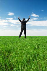 glad businessman standing at the green grass