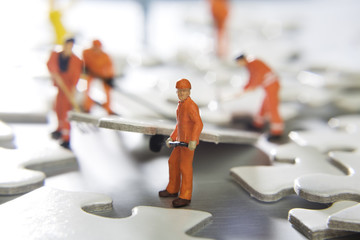 Worker figurines placed with puzzle pieces