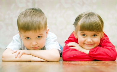 funny boy and a girl lying on the floor