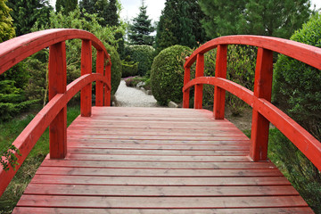 Footbridge in garden with trees and bushes