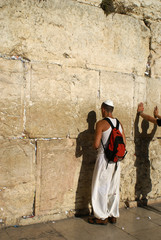 Man praying next to the wailing wall