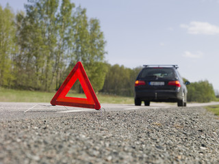 Warning triangle in front of a car breakdown