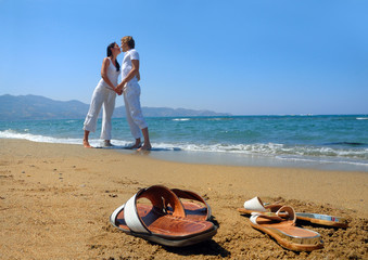 Young attractive couple at the beach (focused front view)