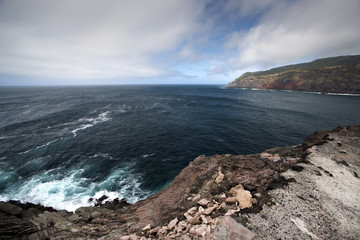azores, terceira island shore seascape with dark clouds and rock