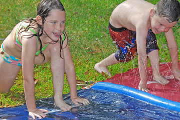 Brother and sister in water play - 14127811