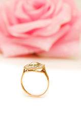 Golden ring and rose at the background