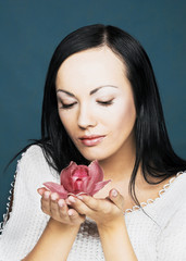 Portrait of young woman with  pink orchid