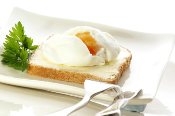 pochiertes Ei auf Toast, Messer und Gabel