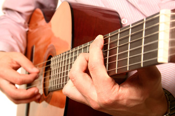 Fototapeta premium Acoustic guitar player close-up with focus on the hand