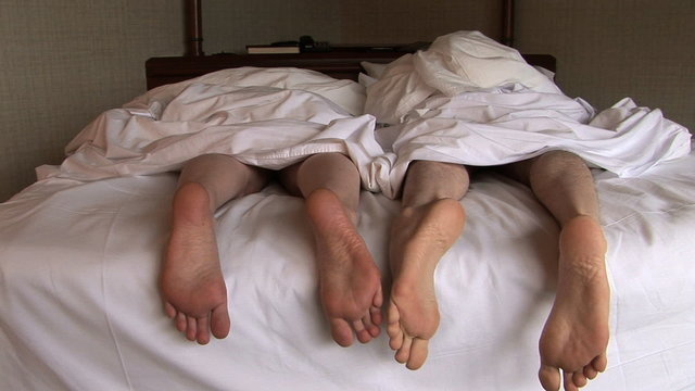 Feet of Couple in Bed