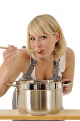 Junge Frau beim Kochen und Abschmecken