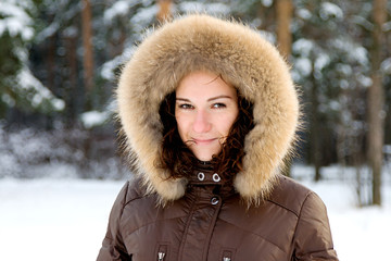 young woman in a hood in winter wood