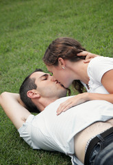 beautiful image of young lovers kissing in the park