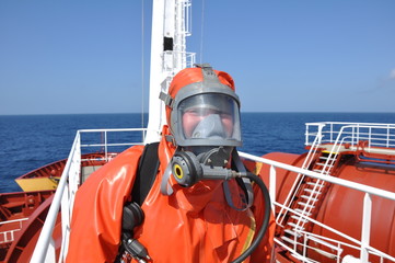 man in chemical suit on deck of chemical tanker - 14226279