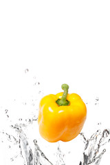 Yellow bell pepper spalshing in water