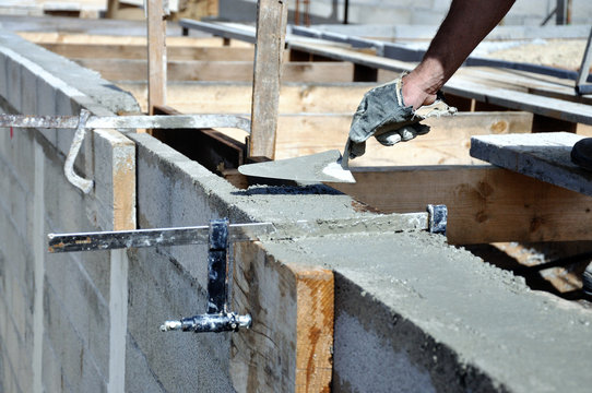 Ma&ccedil;on &eacute;talant le ciment sur le mur