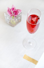 red alcohol cocktail in glass with orchid