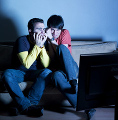 hommes effrayés en regardant la télévision