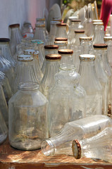 many bottles with rusty lids sitting on a table