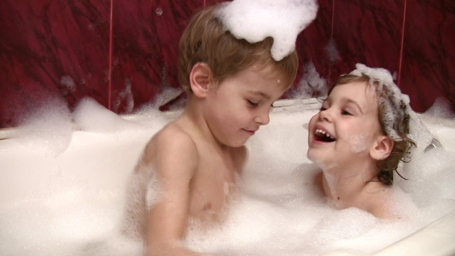 little girl with brother in bath