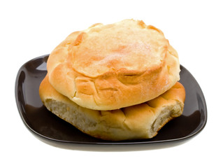 Close-up russian bread loaf stacked on a black plate on white
