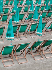 Green deckchairs and umbrellas on the beach