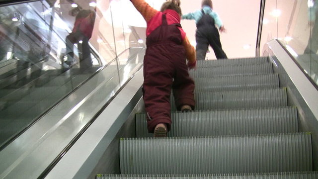 children on escalator in shop