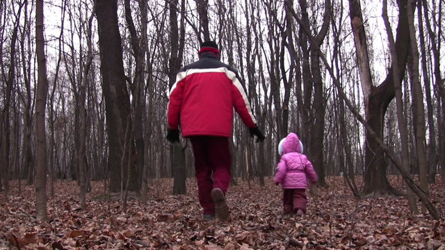 behind walking father and little girl in winter park