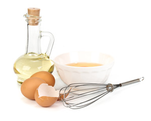 Eggs, oil, cup of milk and whisk