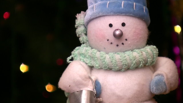 Toy of snowman rotating near christmas tree